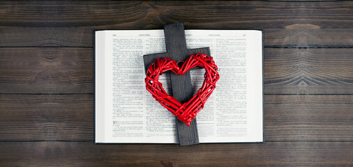 Opened holy bible books on the table. Scripture. Cross of Jesus. The heart is red. On a wooden background