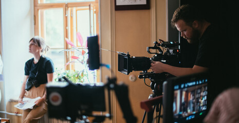 Wall Mural - Director of photography with a camera in his hands on the set. Professional videographer at work on filming a movie