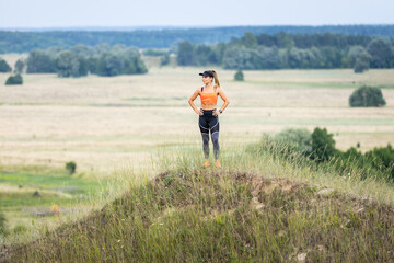 young sporty runner girl standing on the hill