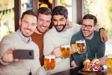 Wall Mural - Group of happy friends have a fun in beer pub