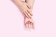 © Zireael - Beautiful female hands on a pink background.