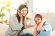 © Tom Wang - Happy daughter and mother listening music with headphones at home