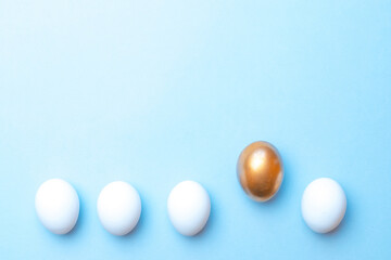 Wall Mural - Easter background blue. Golden, white colour egg on pastel blue background in Happy Easter decoration. Flat lay, top view.