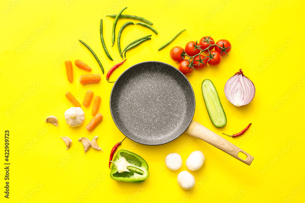 Frying pan and different vegetables on color background - obrazy, fototapety, plakaty 