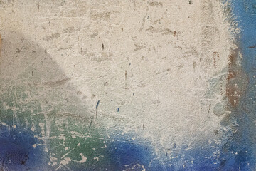 background of aged concrete wall with traces of plaster and blue paint. The consequences of the destruction of architecture by physical impact.