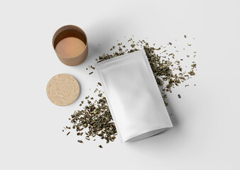 plain white tea packaging paper pouch on dry tea leaves and tea cup - isolated background
