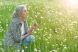 © aletia2011 - Portrait of a beautiful senior woman in green field with dandelions