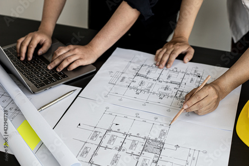 Two architects and engineers are in a meeting to discuss and inspect the house designs to meet the building and construction standards. Interior design and decoration ideas.
