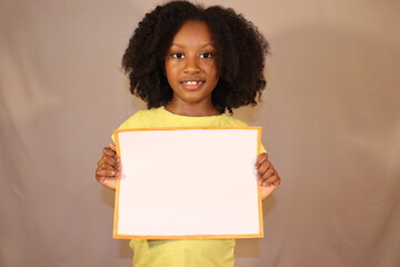 Black Kid holding blank white sign grey background