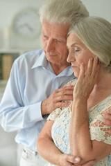 Portrait of sad senior couple posing at home