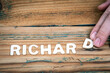 RICHARD. Name of men and boys. Birthday concept. White letters of the alphabet on a wooden background