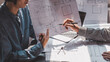 © amnaj - Two people architects working at the office, pointing at the blueprint.