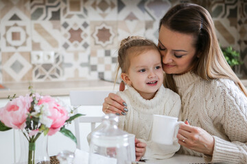 miling mother takes selfie with cute daughter on tablet, happy young mom laughing makes photo with daughter at home, single mom and adopted children playing fun with phone