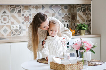 Smiling mother takes selfie with cute daughter on tablet, happy young mom laughing makes photo with daughter at home, single mom and adopted children playing fun with phone