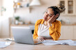© Kateryna - Tired emaciated african american female student or freelancer, sits at her desk with her head on her hand, tired of working online or distance learning, thinking about weekend or vacation, need a rest