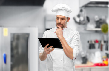 male chef with tablet pc at restaurant kitchen