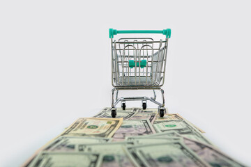 shopping cart on US dollars banknotes road isolated on white background, selective focus