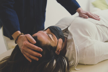 therapist man doing holistic therapy reiki to a woman. energy treatment with the heat of the palm ha