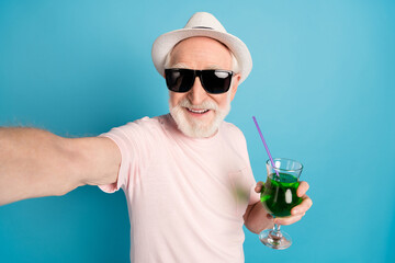 Poster - Photo of aged man happy positive smile drink cocktails make selfie isolated over blue color background