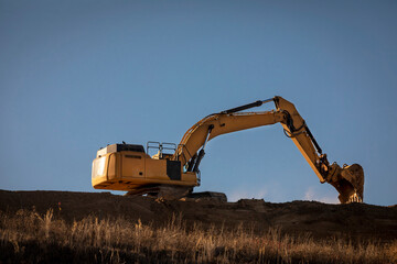 Wall Mural - Excavator on a steep hill at a construction site