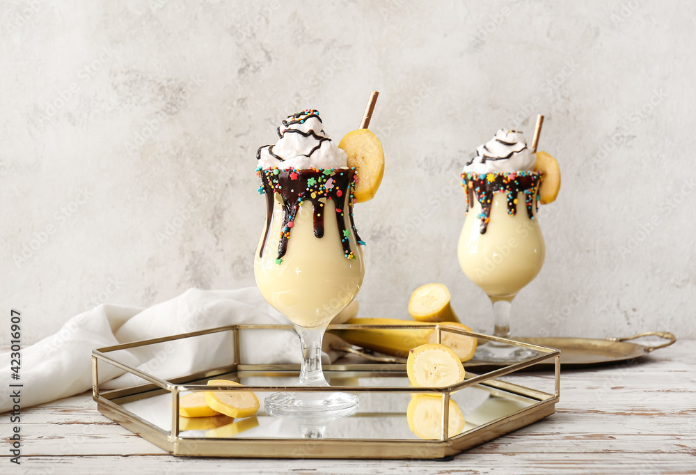 Glasses of tasty banana milkshake on grunge background - obrazy, fototapety, plakaty 