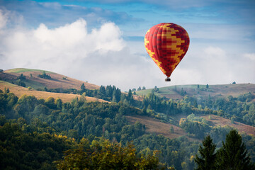 Wall Mural - Hot air balloon flying over mountains