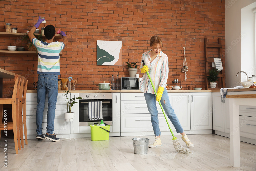 Young couple cleaning their kitchen