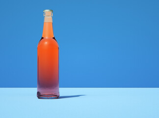 Leinwandbilder - Transparent glass beer bottle on retro light blue color background. Bottle filled with yellow liquid.