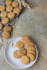 Wall Mural - Oatmeal cookies with cereals, seeds and nuts, concrete background. Healthy vegan cookies. Top view.