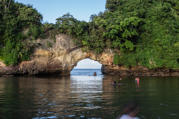 Tumaco, Nariño, Colombia. July 2019: Geological natural arch on El Morro island with plants and blue sky. Seaview