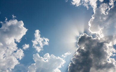 Blue sky with clouds. Crepuscular rays or God rays. Epic cloudy sky with holy sun light beams.