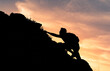 © kieferpix - Young man climbing up steep edge of mountain