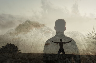 Young man feeling free in a mystic mountain setting. Seeing the light, and inner peace concept. 