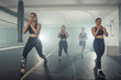 Group of sportswomen in sportswear doing lunge exercise at the gym with their right leg