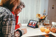 © Dani Navarro/ADDICTIVE STOCK - Side view of smiling homosexual elderly women watching tablet with happy children and mothers during video chat at home