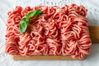 © Leire Gamboa/ADDICTIVE STOCK - From above of fresh raw mixed pork and beef minced meat on wooden cutting board with green basil leaves placed on table during cooking process