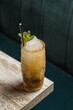 © Ramon Lopez/ADDICTIVE STOCK - From above of tiki cup with cold alcohol drink with straw served with ice and decorated with fresh herb placed on blurred background