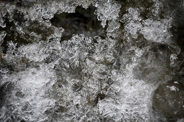 Ice-free little river in winter. Stream of river water. The snow cover. Winter abstract background.