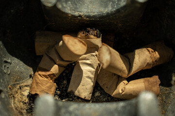 Old cigarettes in a metal ashtray 