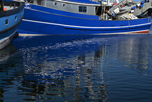 Blue Fishing Boats Reflecting On Blue Water