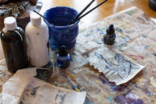 Art Supplies On A Desk With A Drawing Of Flower Buds In Natural Light.