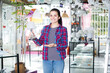 © JackF - Young woman demonstrates a glass table lamp in a light store