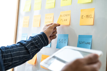 Poster - Young creative business people use post it notes sticky note on board to share idea, Analysis data chart and graph with planning strategy thinking in office