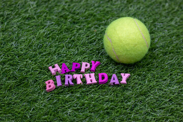 Wall Mural - Happy birthday to Tennis player with tennis ball on green grass