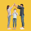 © Tom Wang - Family in medical masks and showing home and protected gesture concepts