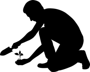 silhouette of man with shovel and plant in hand