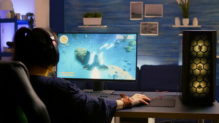 Esport video game r wearing headset and playing online video game for space shooter championship. Online streaming cyber performing gaming tournament using modern technology network wireless