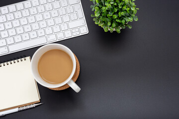 Wall Mural - Top view work space Coffee cup with Keyboard and pen on notebook  on black background with copy space