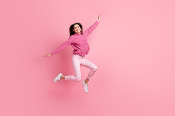 Poster - Full size photo of brunette girl jump wear pink sweater pants sneakers isolated on crimson background