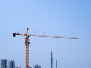 The tower crane on the construction site is busy working